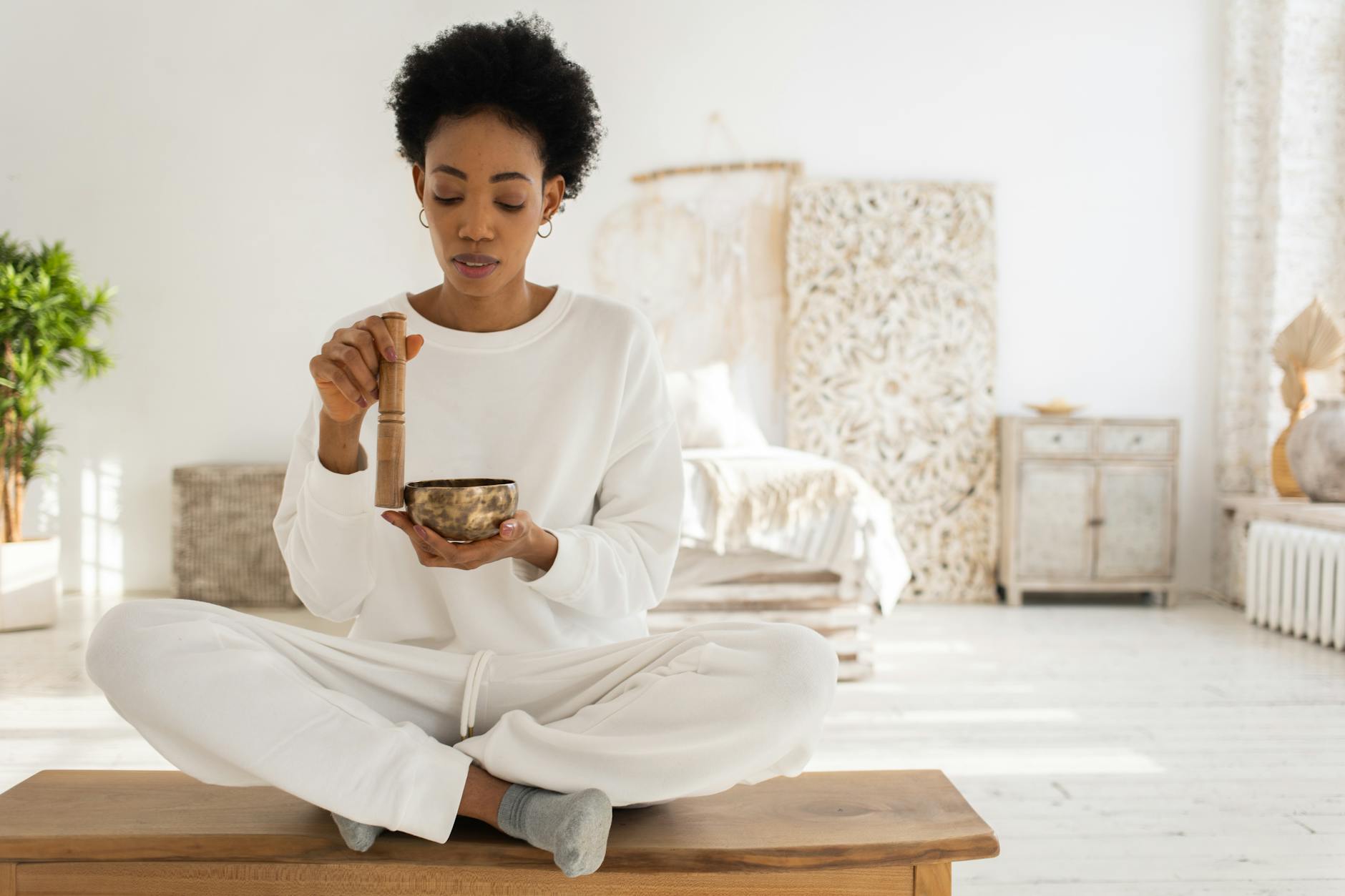 a woman using a singing bowl while sitting